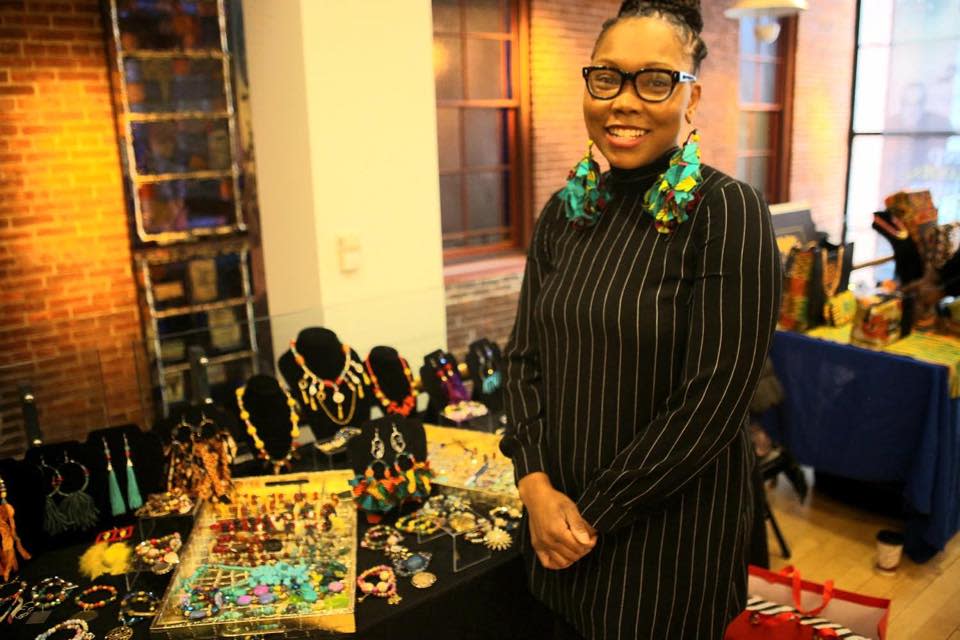 A black woman stands in front of a jewelry display