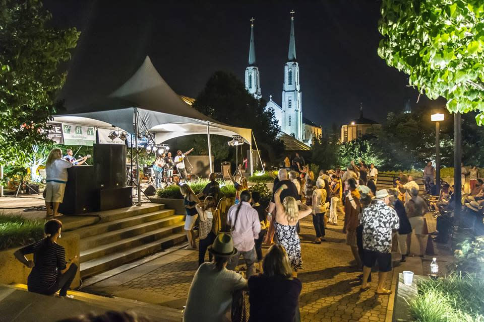 A group of people dancing and listening to a band perform in an outdoor venue in the Botanical Conservatory