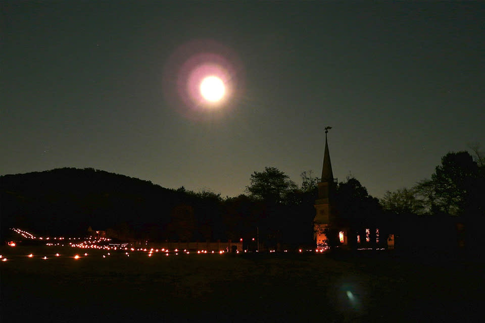 The Historic Daniel Boone Home property lit by lanterns and moonlight.