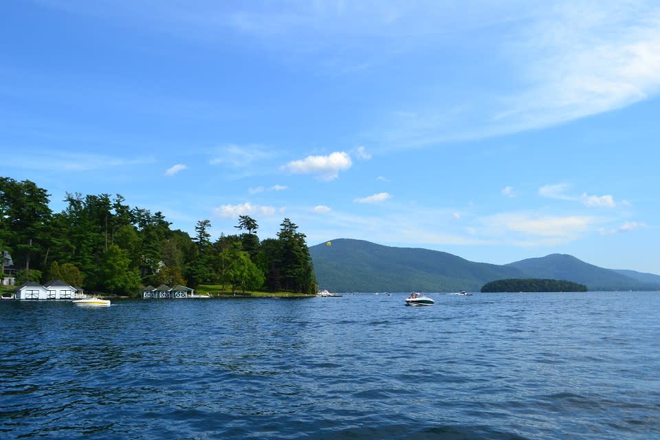Boats on Lake George with the Adirondack Mountains in the background and camps on the shoreline