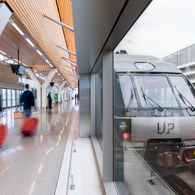 The UP Express train at Toronto Pearson station and passengers walking