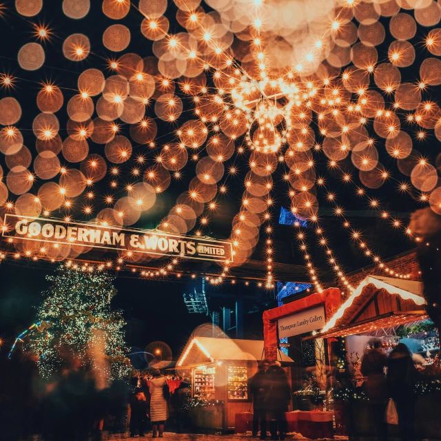 String lights, booths and people visiting the Toronto Christmas Market in the Distillery District