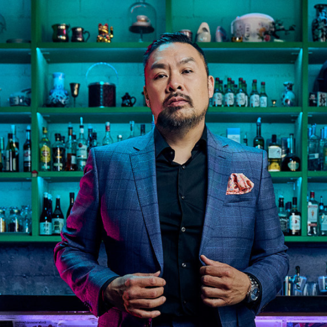 Trevor Lui Stands in front of a bar wearing a suit