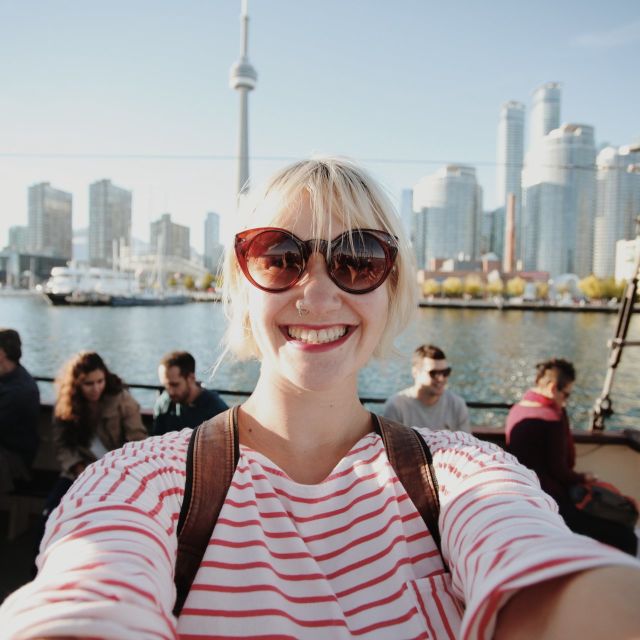 Person on boat with city skyline in the background along Toronto Waterfront