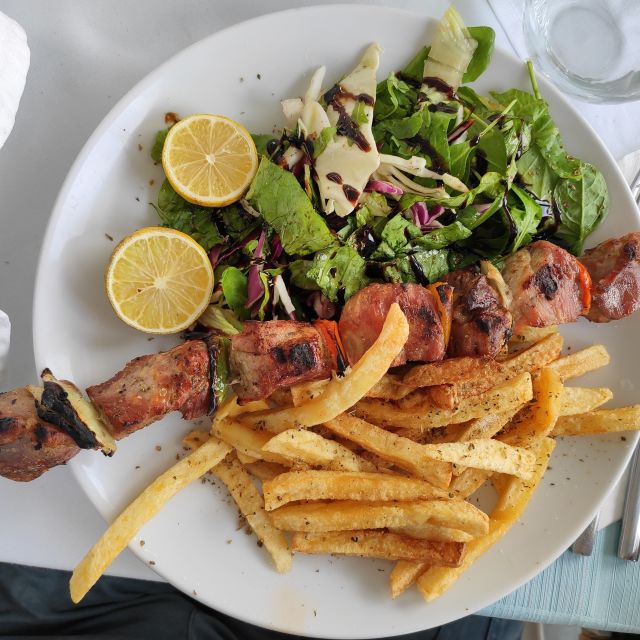 Greek food, including souvlaki and salad.