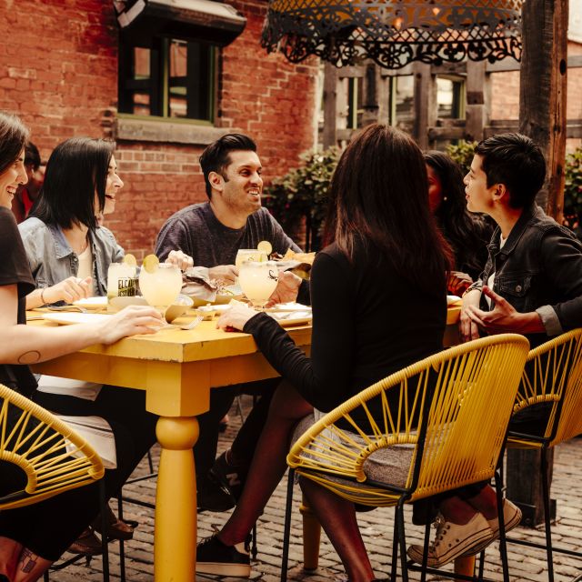 Friends dining on the patio at El Catrin restaurant in Toronto's Distillery District