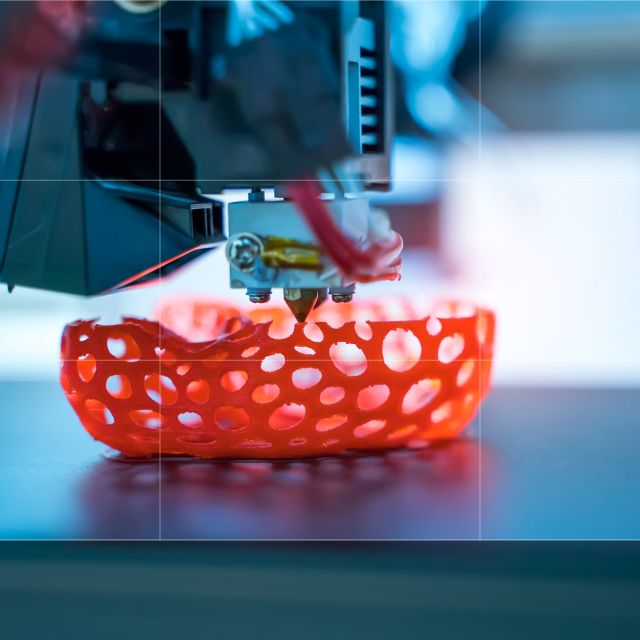 3D printer produces an orange object