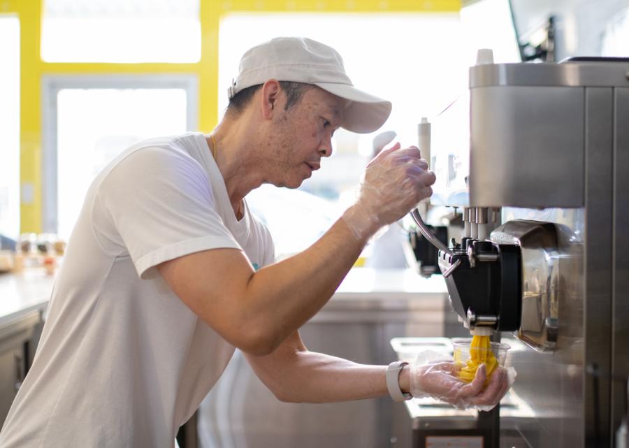 Miruku owner serving soft serve ice cream from machine