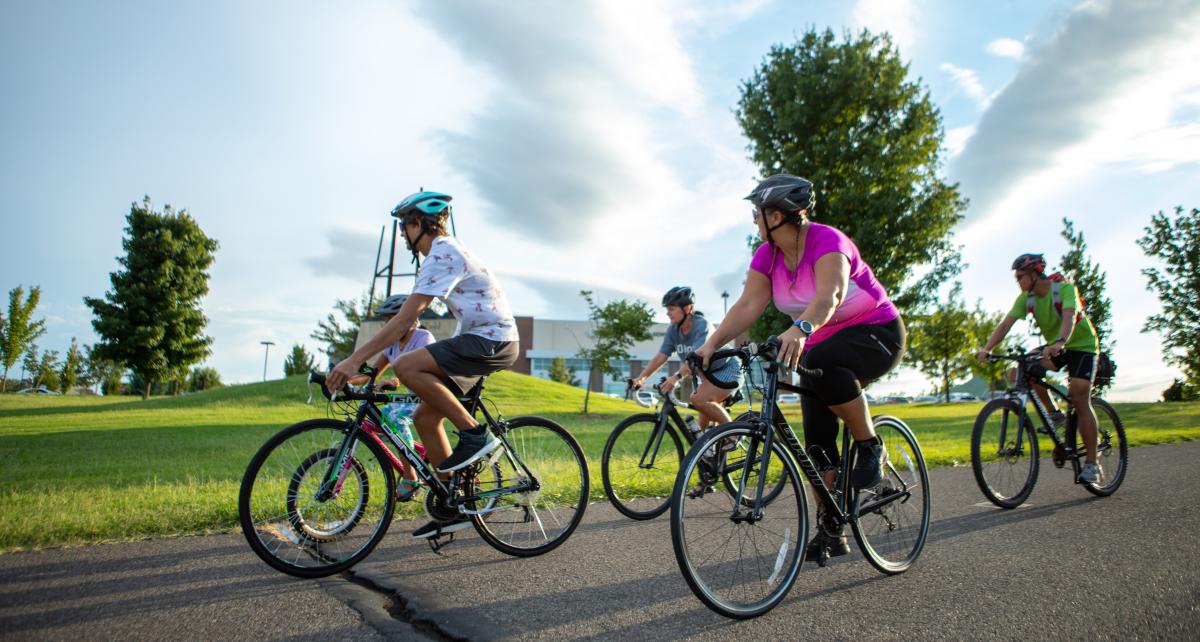 Individuals riding their bikes through a park.