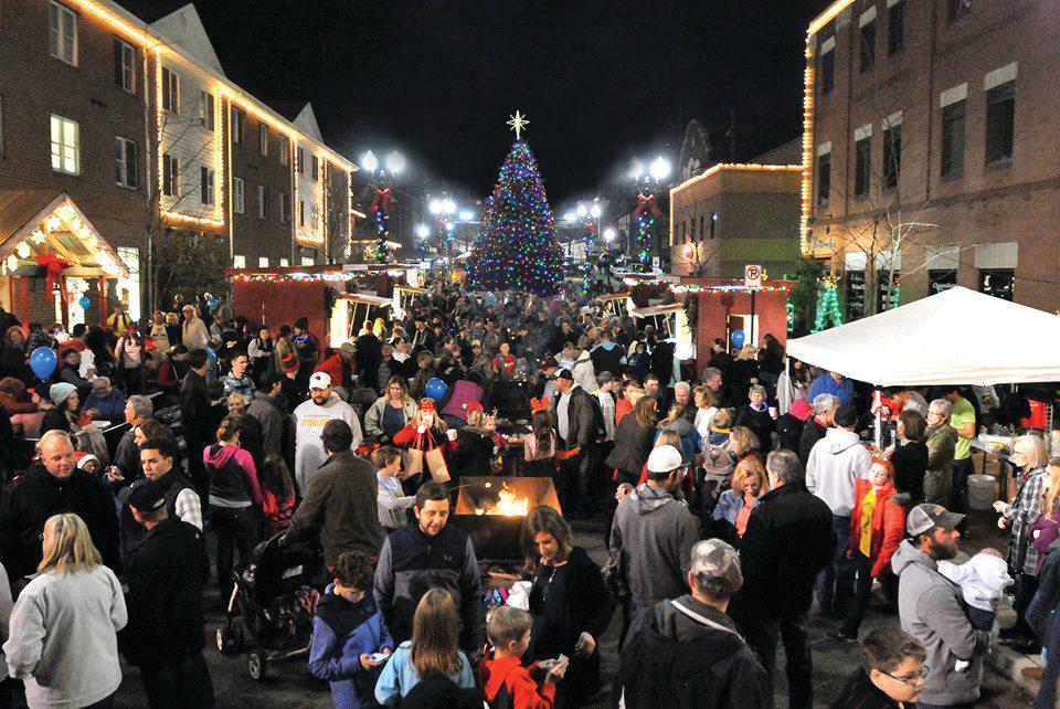 Group of People on main street Holiday Lights around Christmas Tree