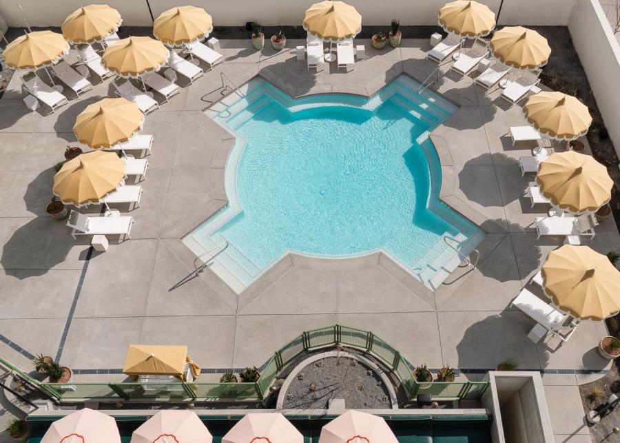 An overhead photo of the Zia-shaped pool at ARRIVE Albuquerque. The pool is surrounded by pool loungers.