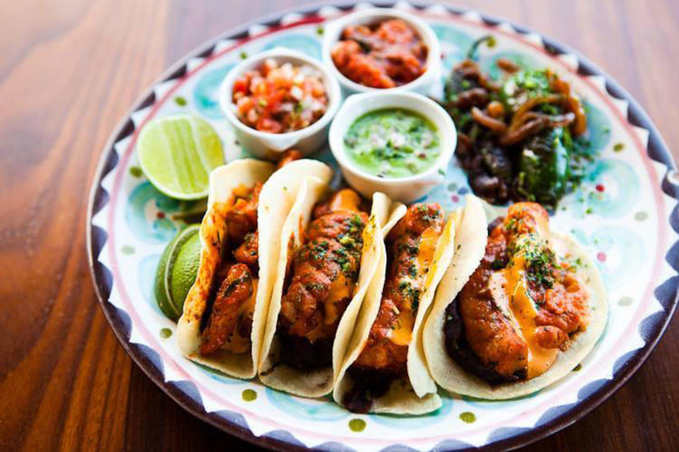 Cuatro tacos servidos con  guacamole y chiles para una deliciosa comida en el restaurante del hotel Hacienda en Los Cabos