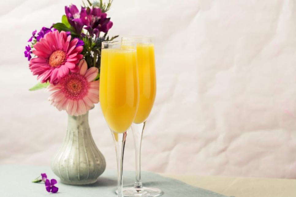 Mimosas in front of a vase with pink and purple flowers