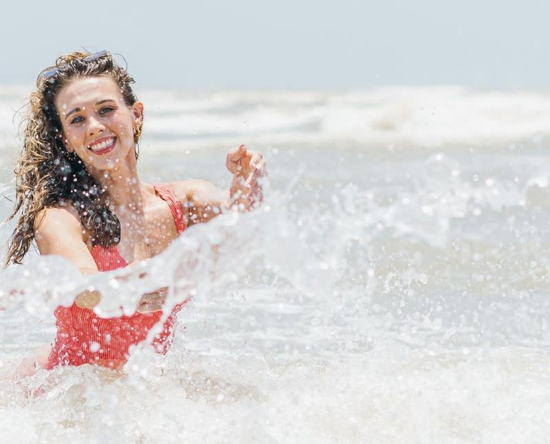 A girl swimming in a red swimsuit.