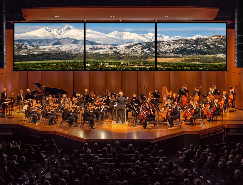 Image of the fort collins symphony playing with rocky mountains in the background