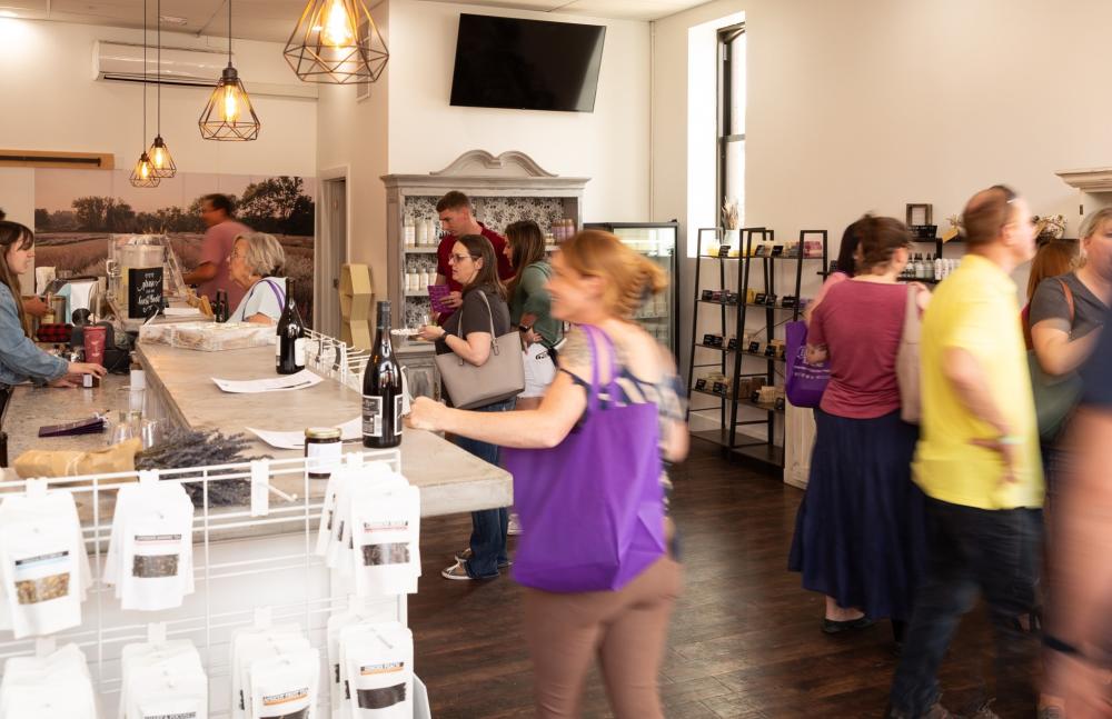 Visitors shopping inside shop full of lavender made products, including packaged fresh and dried lavender.
