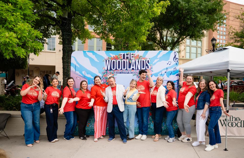 Visit The Woodlands staff and Chairman of The Board pose in front of their mural at Market Street for National Travel and Tourism Week. From left: Josie Lewis, Brooklyn Newell, Rachael Varner, Amber Parsley, Elizabeth Eddins, Nick Wolda, Linda Nelson, Ryan Greenwood, Julie Quinn, Carla Twidell, Vargo Williams, Ashley Fenner, and Andrea Day.
