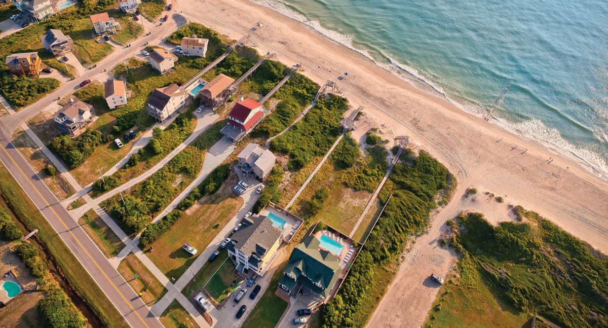 An aerial shot of beach-front rental homes situated on the coast of the Outer Banks in North Carolina.
