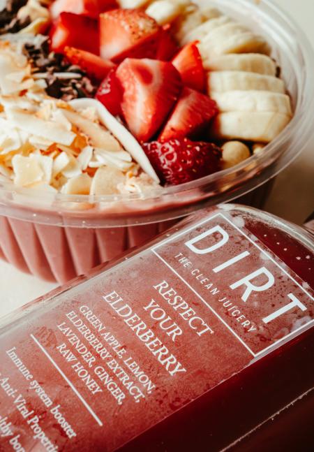Close up image of Banana Split smoothie bowl and "Respect your Elderberry" juice from DIRT Juicery.