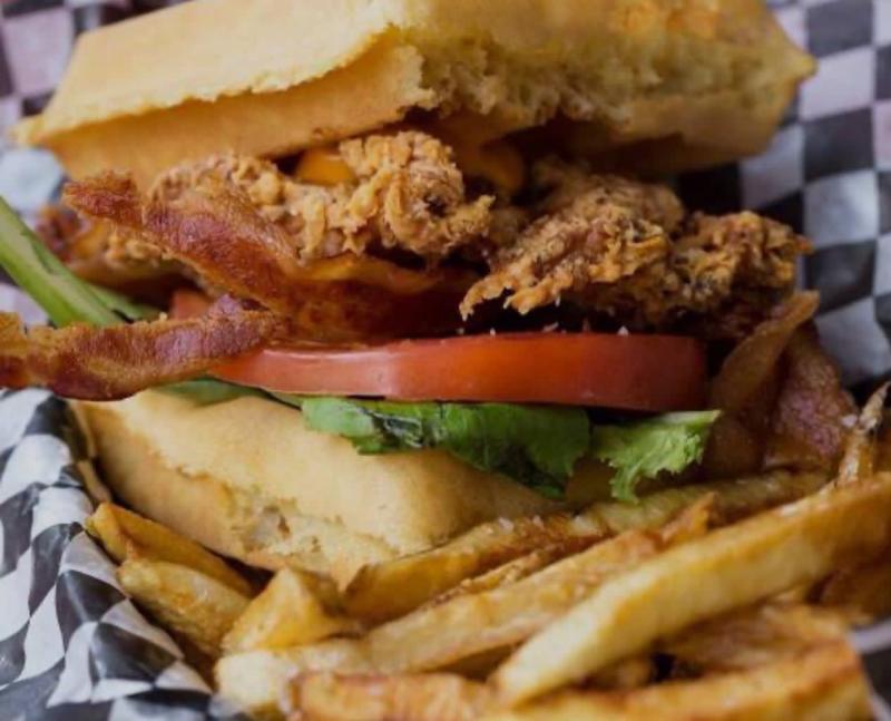Waffle sandwich with chicken, lettuce, tomato, and french fries