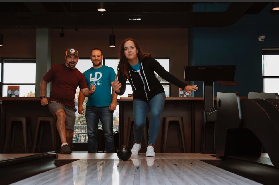 Three people enjoy duckpin bowling at Lansing Duckpin.
