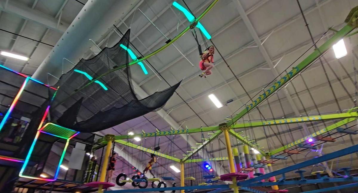 A girls soars on the zipline at Urban Air Adventure Park