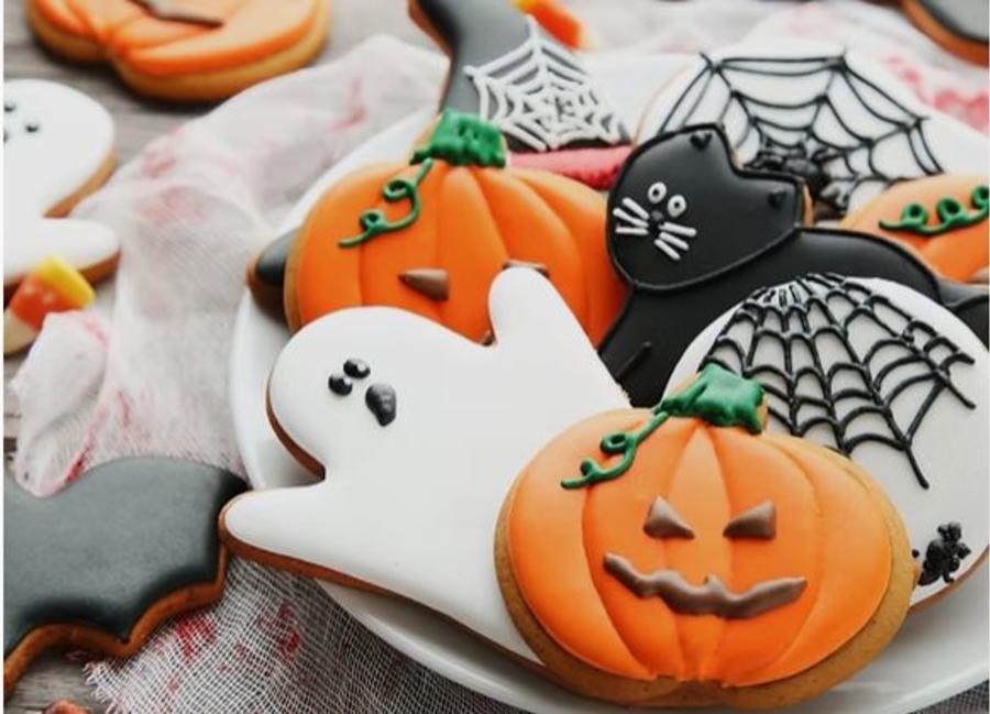 Halloween-themed iced biscuits decorated as pumpkins, ghosts, cats and spiderwebs at Elkstone Studios in the Cotswolds.