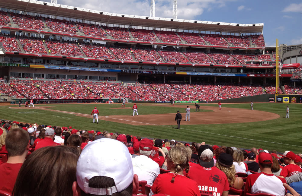 Cincinnati Reds fans in red shirts watch the baseball team play in Great American Ball Park