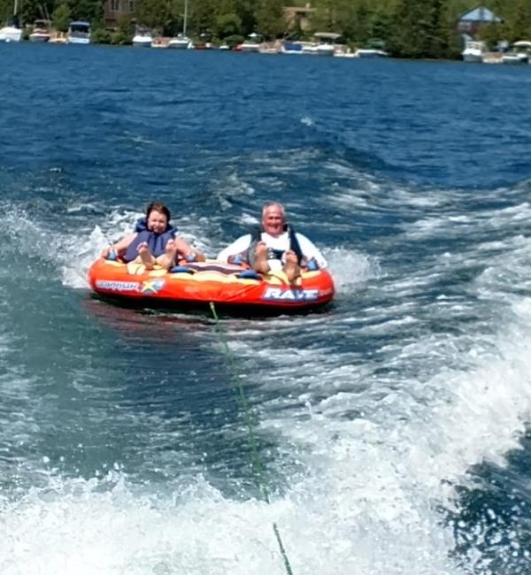 Old man and kid tubing on water