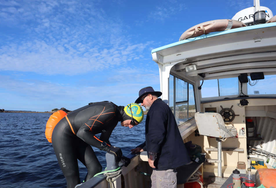 Wez Swain descending a boat to start the swim challenge