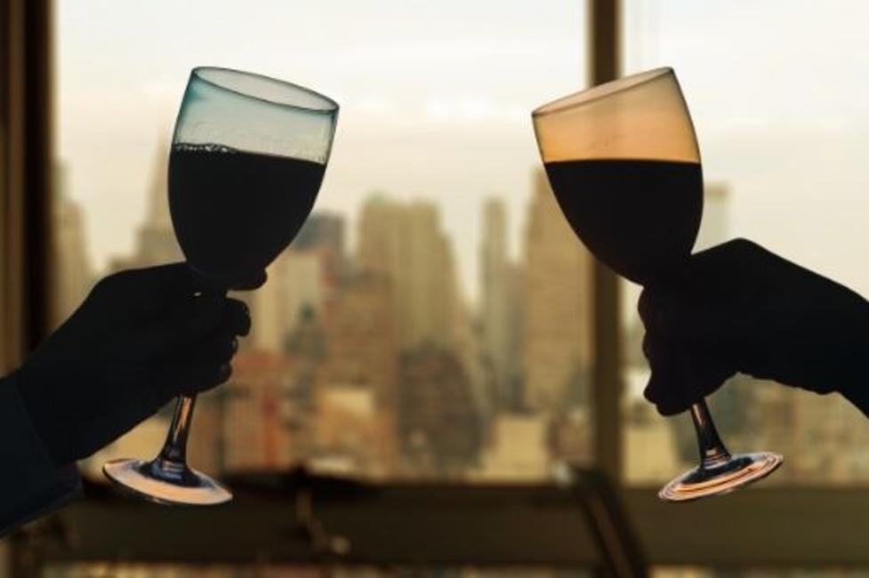 Date night in NYC Two wine glasses about to clink with background view of Manhattan