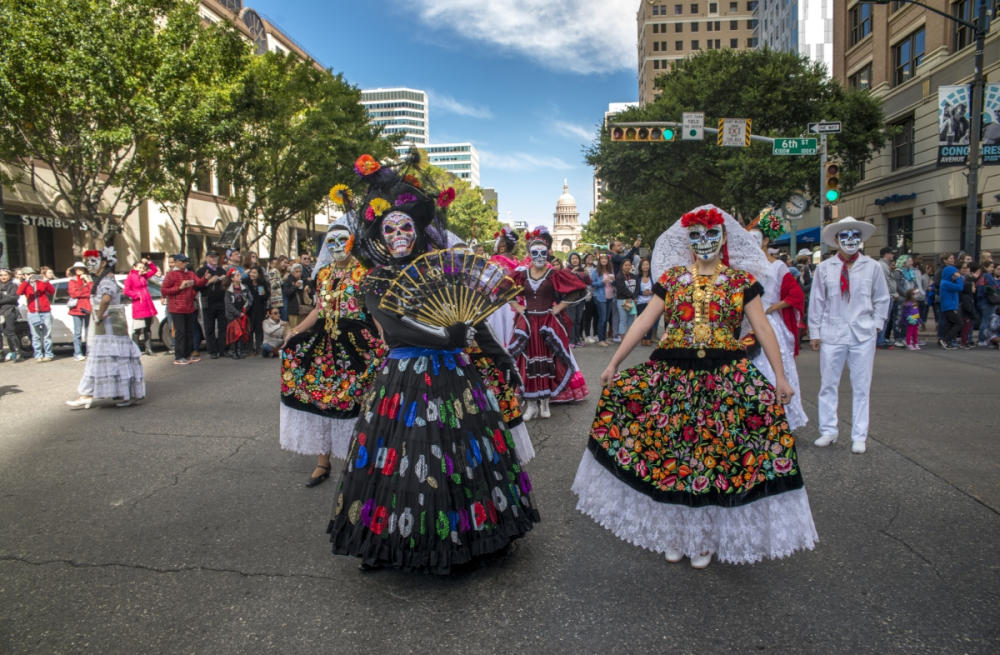 Viva la Vida Parade down congress avenue with women in dia de los muertos costume