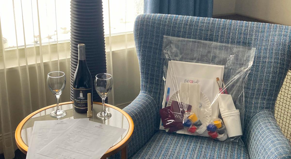 A bottle of wine and two glasses sit on a table