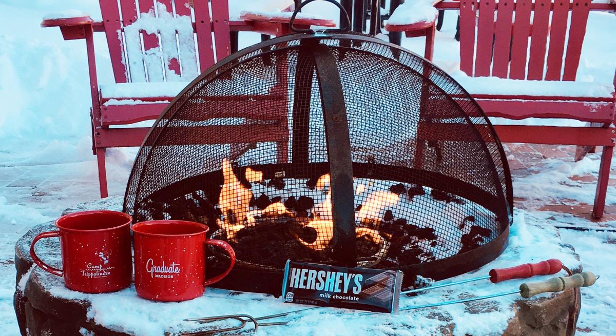 Mugs and s'more fixings by a firepit at Graduate Madison hotel
