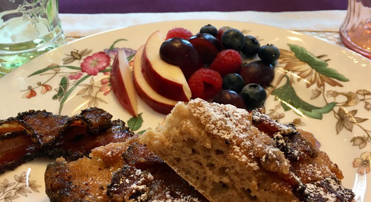 A plate of fresh fruit among other breakfast food items