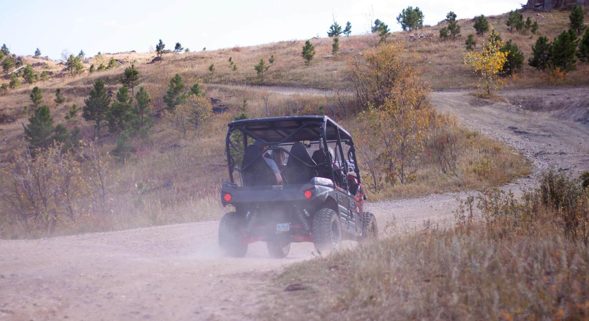 atving kicking up dirt along a trail found in the black hills national forest