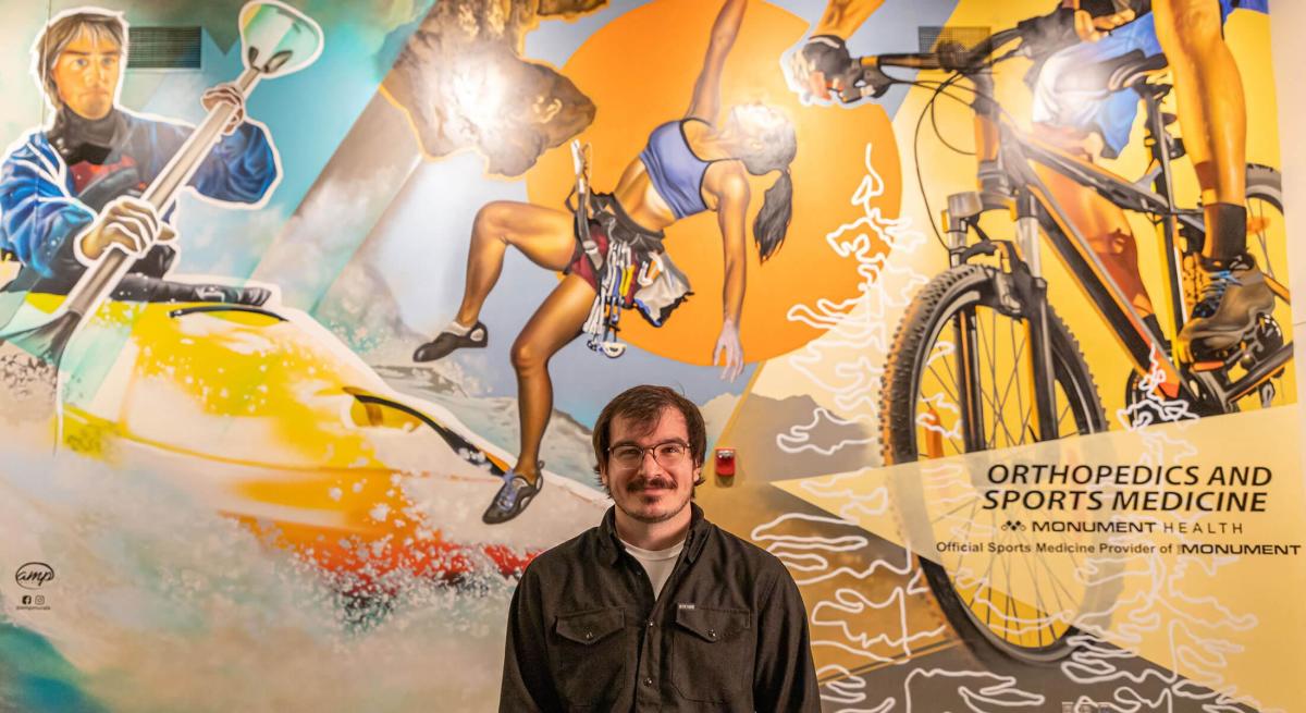 Aaron Pearcy in front of his mural at The Monument in Rapid City, SD