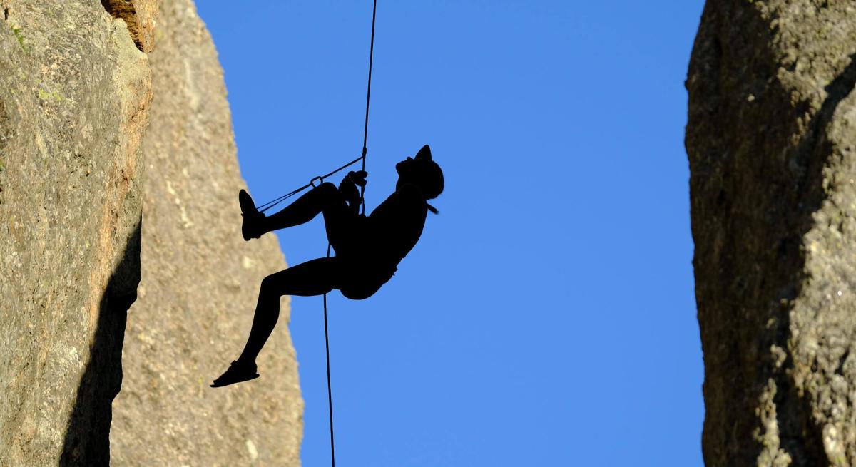 Black hills rock climber repelling on a climb in South Dakota