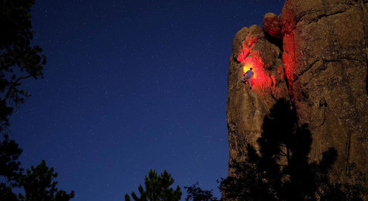 Night rock climber on Second Hand Rose Arete in the Black Hills of South Dakota