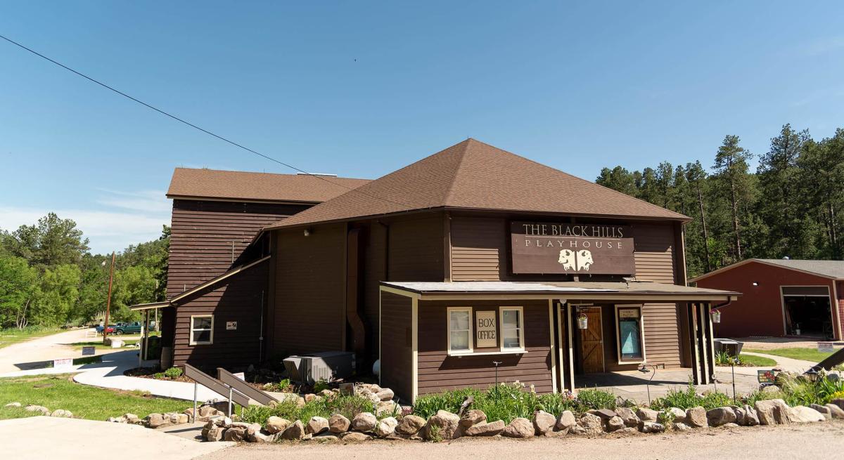 Exterior of black hills playhouse found surrounded by trees in a natural setting in custer state park