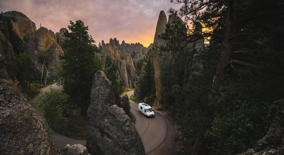View of a van cruising through the granite pillars of Needles Highway in Custer State Park