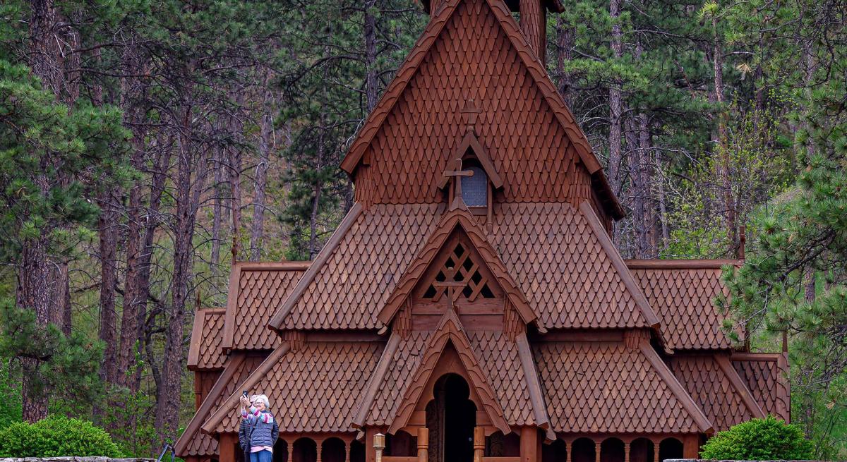 couple taking a selfie in front of the norwegian chapel in rapid city south dakota