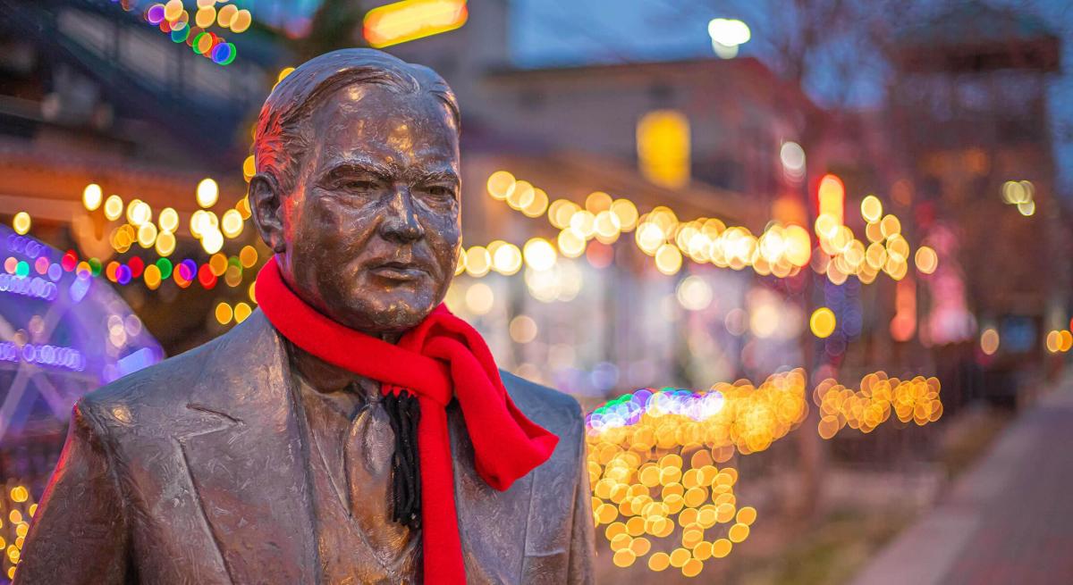 Herbert Hoover in scarf with christmas lights behind