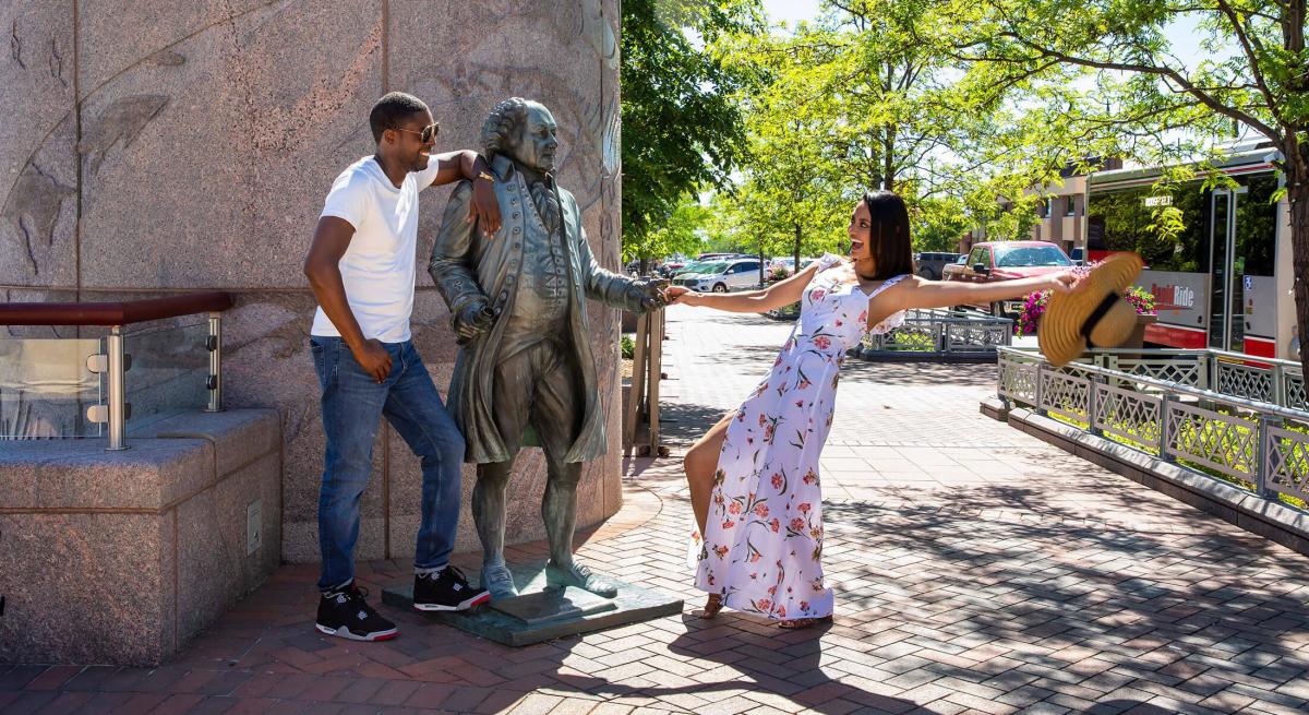 Couple posing with John Adams statue in Rapid City