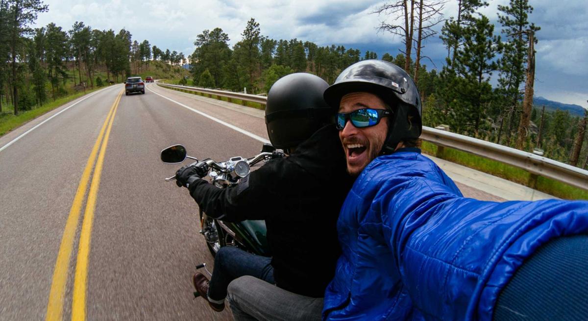 Motorcycle passenger takes selfie while cruising in the Black Hills