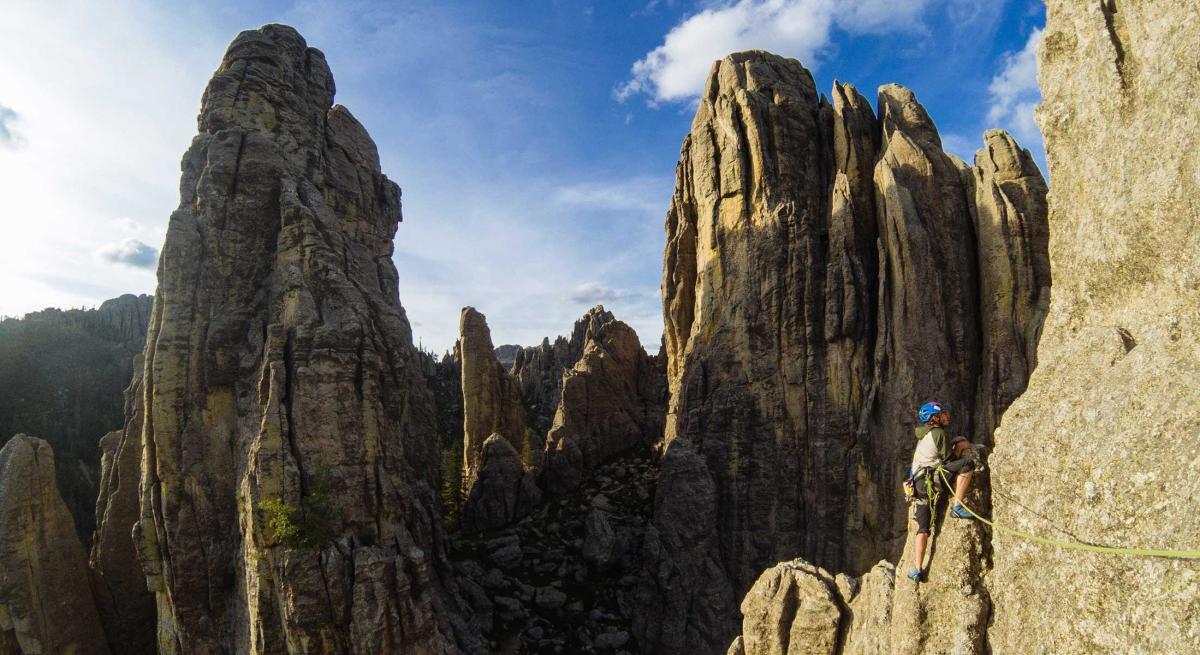 Rock climber climbing the spires of Cathedral Spires in Custer State Park