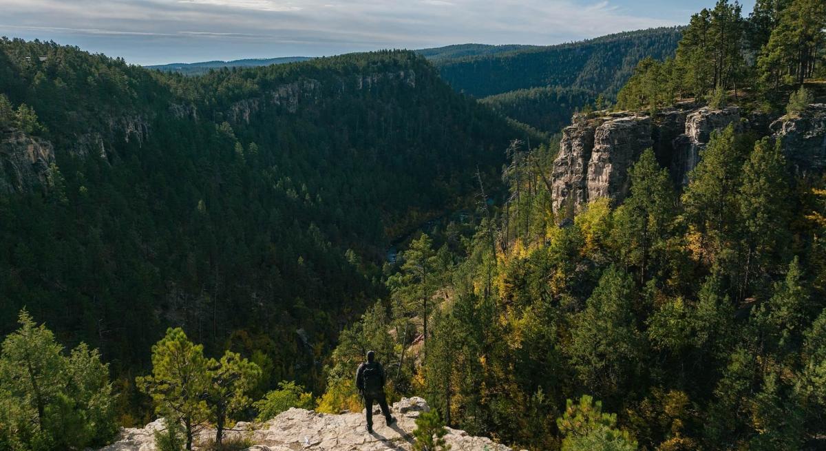 hiker on cliff overlooking the black hills national forest near Rapid City, SD