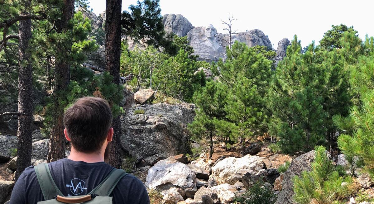 Hiker looking at mount rushmore from the Blackberry Trail in the black hills