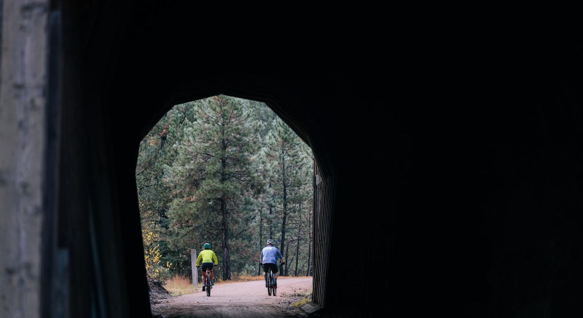 two bikers exiting one of the tunnels found along the rails to trails route of the george s mickelson trail in the black hills