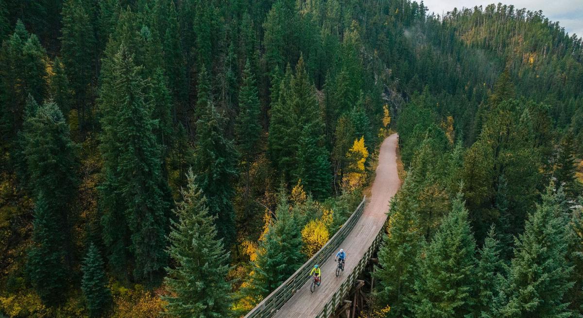 drone shot of two bikers going across a bridge on the mickelson trail in south dakota